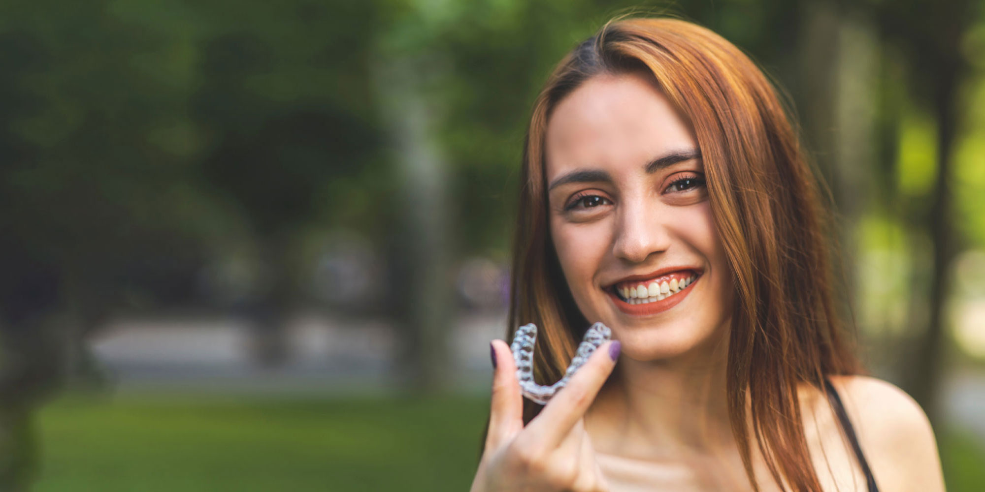 person outside with clear aligner
